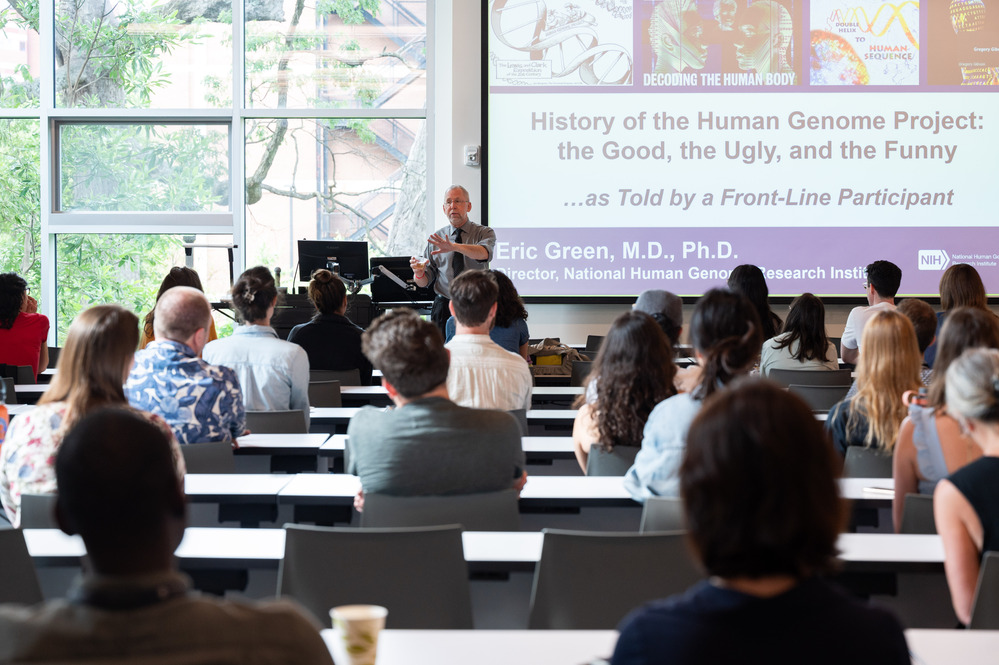 person presenting a slide deck to a room full of people