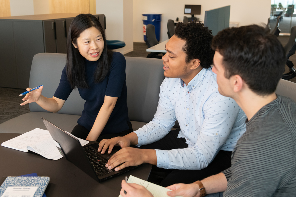 3 Tech community members working together with one laptop and papers in front of them